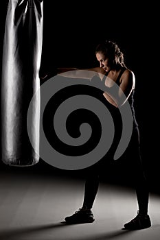 Kick fighter girl punching a boxing bag