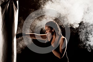 Kick fighter girl punching a boxing bag