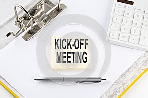 KICK-OFF MEETING - business concept, message on the sticker on folder background with calculator