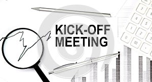 KICK-OFF MEETING text on document with pen,graph and magnifier,calculator