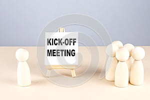 KICK-OFF MEETING text on easel with wooden figure, meeting concept