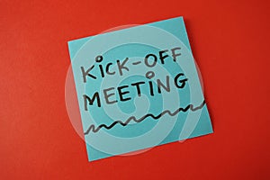 Kick-off meeting text handwritten on blue sticker