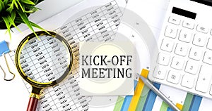 KICK OFF MEETING text on sticker on diagram with magnifier and calculator. Business concept