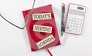 KICK OFF MEETING text on sticker on red notebook with pen and glasses