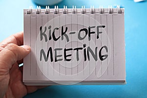 Kick-off meeting, text words typography written on paper against on blue background, life and business motivational inspirational