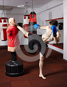 Kickbox fighter working with the dummy