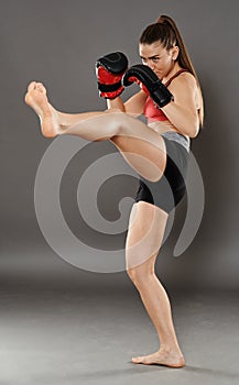 Kickbox girl delivering a kick
