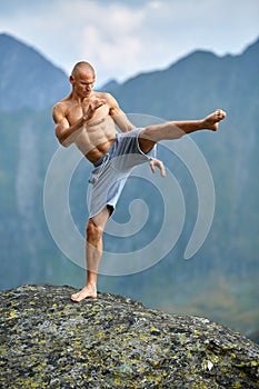 Kickboxer or muay thai fighter training on a mountain cliff