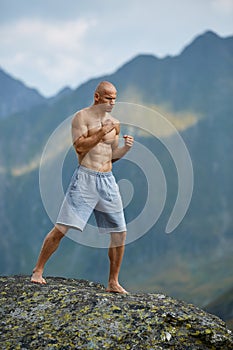 Kickboxer or muay thai fighter training on a mountain cliff