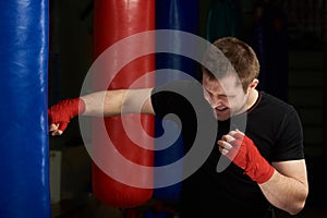 Kickboxer punching sand bag