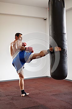 Kickboxer training with punchbag