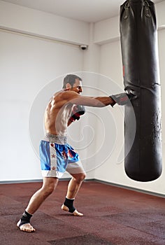 Kickboxer training with punchbag