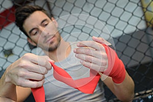 Kickboxer wraps hands red bandages