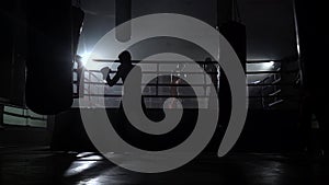 Kickboxers beating a pear in a dark ring