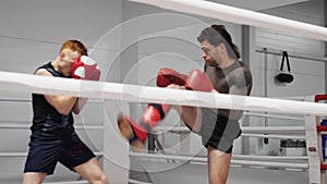 Kickboxers training roundhouse kick on ringside in sparring in fight club.