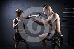 Kickboxing coach is training the boy. The concept of family, sports, mma, muay thai