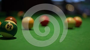 Kicking of balls with pool stick on table with green fabric