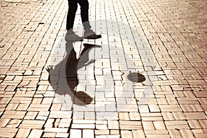 Kicking it by myself. Cropped image of a single pair of legs kicking a soccer ball casting a shadow.