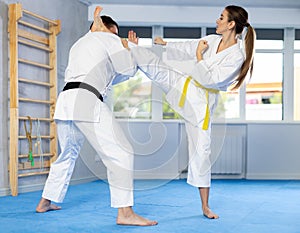 Kicks training during sparring between man and woman in karate training in gym
