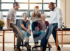 Kickstarting the work week with a team meeting. a group of businesspeople having a discussion in a modern office.