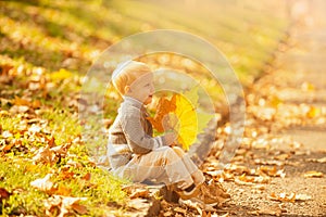 Kid with autumn leaves in the beauty park. Happy child dreams outdoors in autumnal background. Dreaming kids.