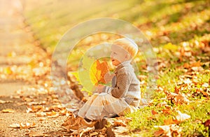 Kid with autumn leaves in the beauty park. Happy child dreams outdoors in autumnal background. Dreaming kids.