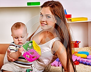 Kid baby boy with mother plying puzzle toy on