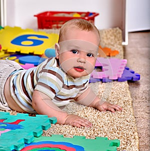 Kid baby boy plying with puzzle toy on floor