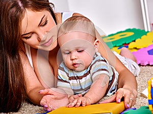 Kid baby boy plying with puzzle toy on floor