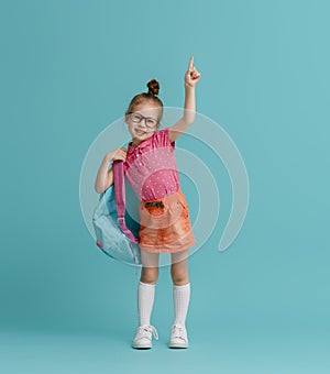 Kid with backpack on color background