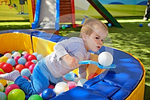 Kid in ball pit having fun in children play center