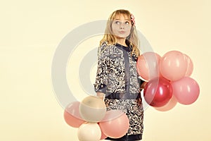 Kid with balloons at birthday. Small girl child with party balloons, celebration. Little girl with hairstyle hold