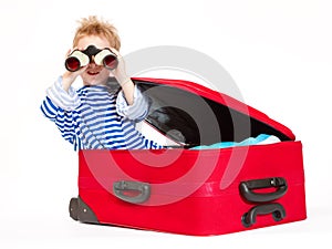 Kid with binoculars sail in suitcase