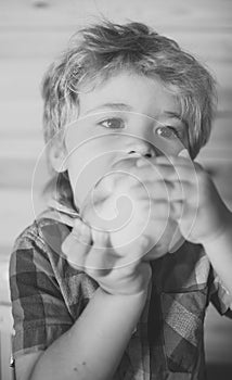 Kid or blonde happy boy eating apple.