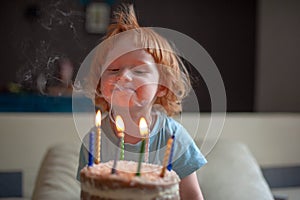 Kid blows out candles on holiday cake