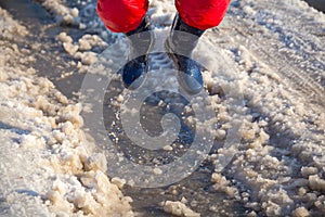Kid in rainboots jumping in the ice puddle photo