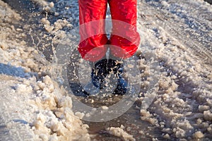 Kid in rainboots jumping in the ice puddle photo