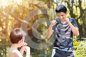 Kid boxing. young boy boxer  practice muay Thai punches with father coach