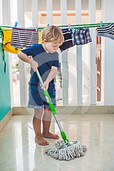 Dítě chlapec čištění patro. malý pomocník. 