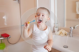 Kid boy cleaning teeth in bathroom