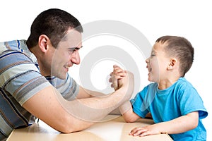 Kid boy and dad competing in physical strength