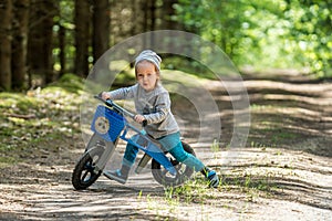 kid boy in forest with balance bike