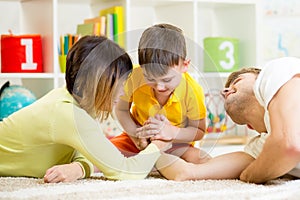 Kid boy, his father and mother competing in physical strength