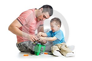 Kid boy and his father repair toy car