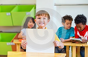 Kid boy holding blank paper with back to school word with diversity friends and teacher at background,Kindergarten school,mock up