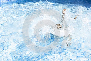 Kid boy holding breath underwater in sunny swimming pool. learning to swim