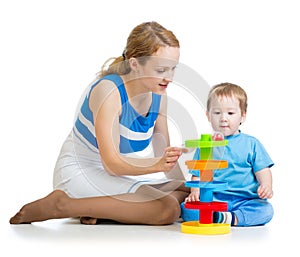 Kid boy and mother playing together with toy