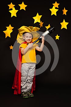 Kid boy playing sky watcher with a telescope