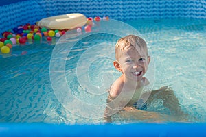 Kid boy playing in small baby pool