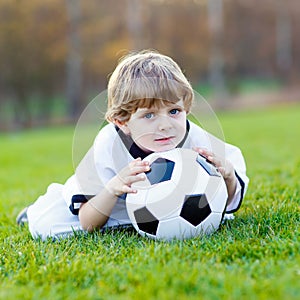 Kid boy playing soccer with football